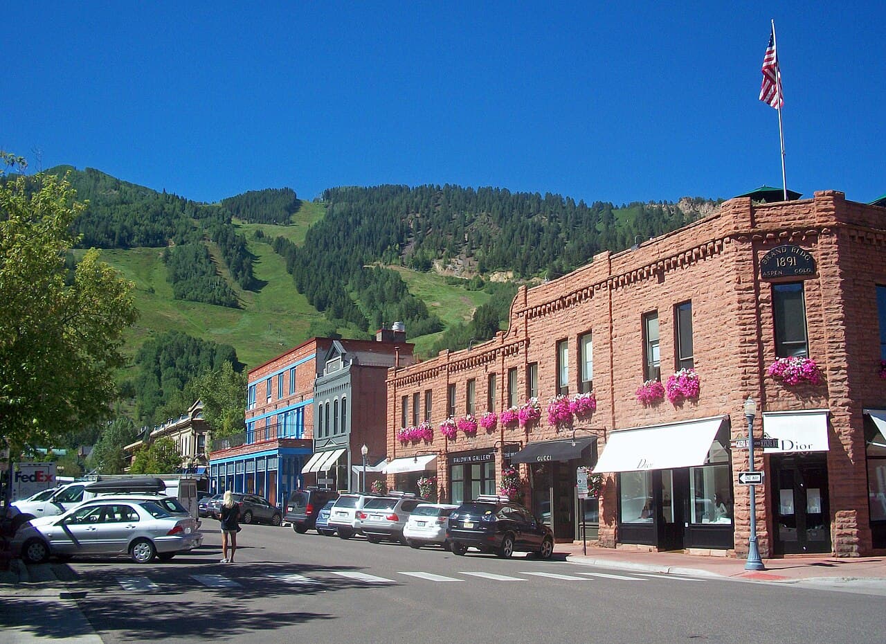 Street in downtown Aspen, Colorado with the ski runs of Aspen Mountain rising behind